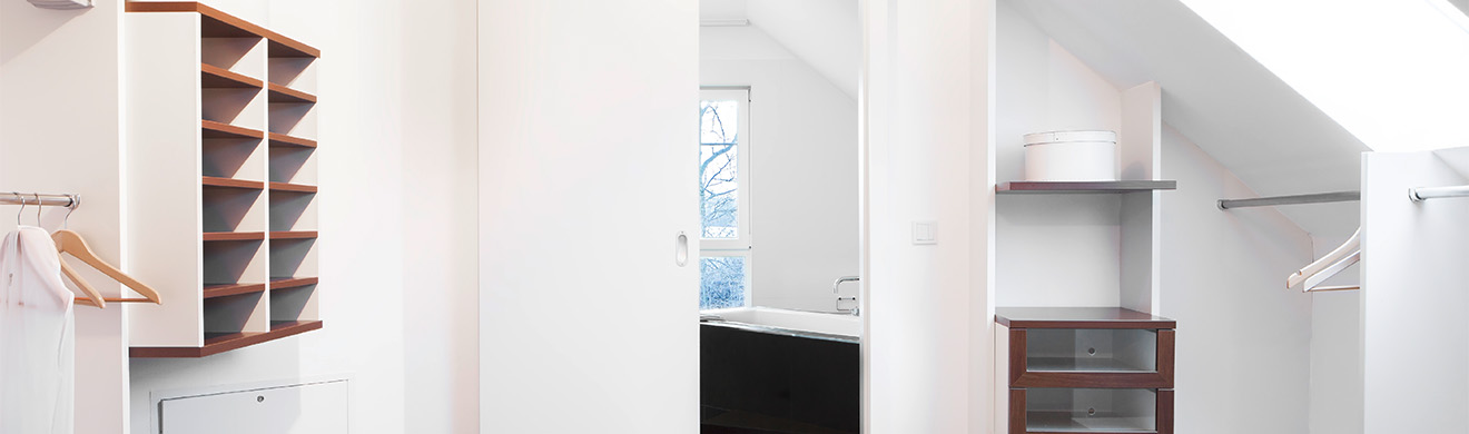 Modernes Ankleidezimmer mit maßgefertigten Einbauschränken aus Holz, übersichtlicher Stauraum und hochwertiger Innenausbau durch Bauschreiner in Mainz.
