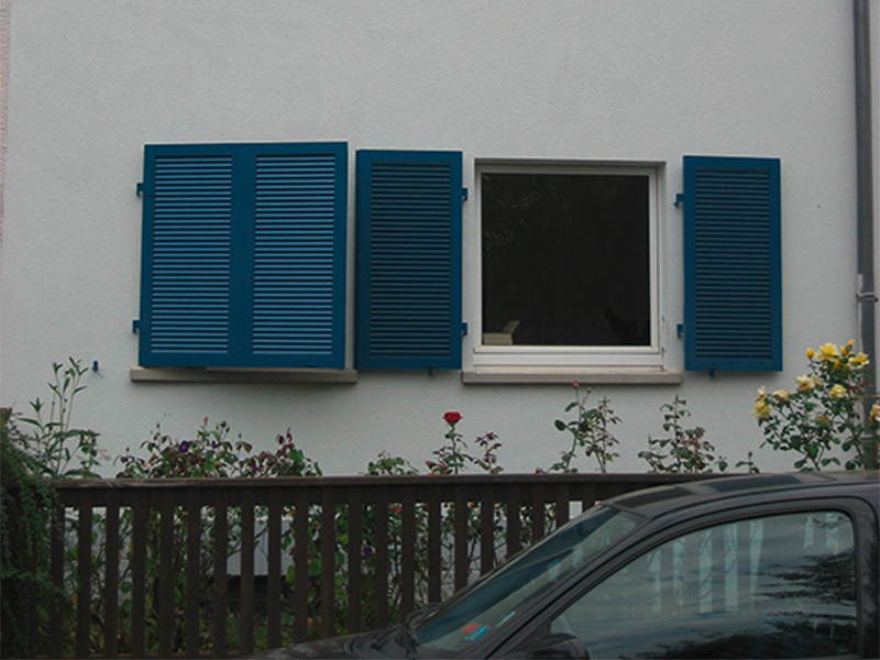 Klappläden aus Holz an einer Hausfassade in Mainz mit klassischer Optik und funktionalem Sonnenschutz für Fenster.