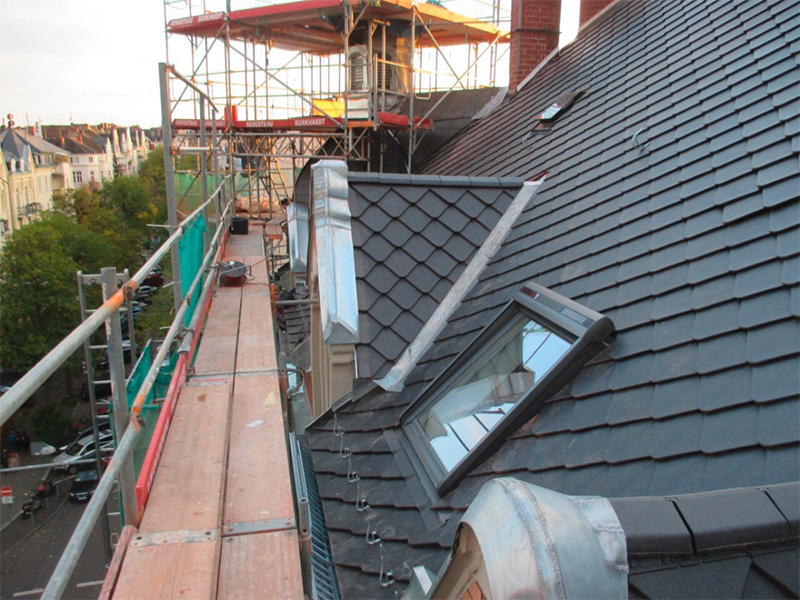 Sanierte Dachfläche mit Dachfenster und Gerüst bei umfassenden Dacharbeiten im Zuge einer Dachsanierung durch Fachbetrieb in Mainz Region.