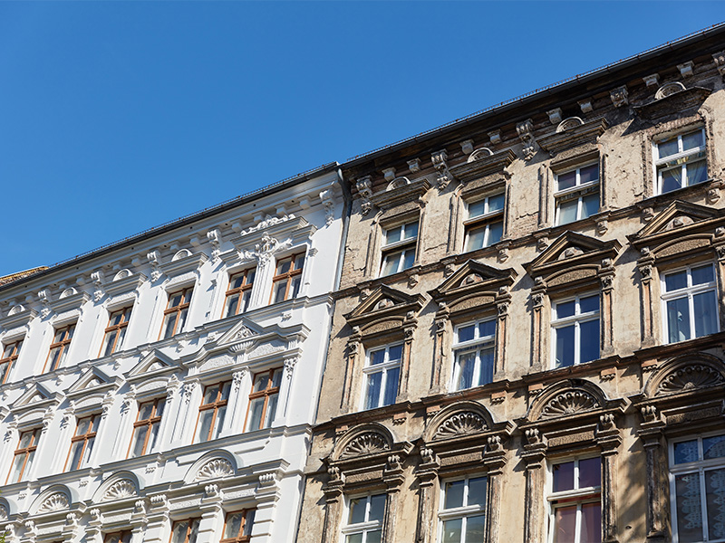Sanierte Altbaufassade mit historischem Charakter und denkmalgerechtem Anstrich zur Erhaltung wertvoller Gebäudedetails.