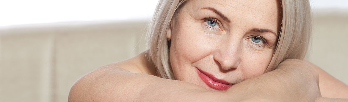 Eine 50-jährige Frau ist sehr zufrieden mit ihrem gepflegten Gesicht