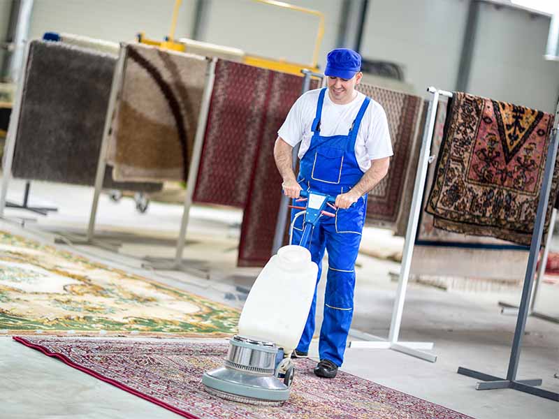 Mitarbeiter eines Teppichreinigungsunternehmens in Mainz reinigt einen Perserteppich