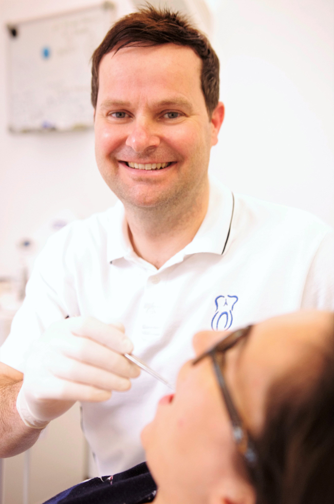 Zahnarzt Uli Hangen aus Mainz im Portrait in moderner Praxisumgebung mit freundlichem Ausdruck und professioneller Ausstrahlung